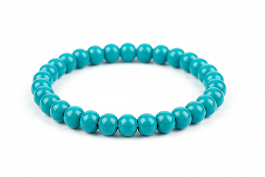 a small beaded porcelain bracelets in vibrant medium blue-green glaze on a white background