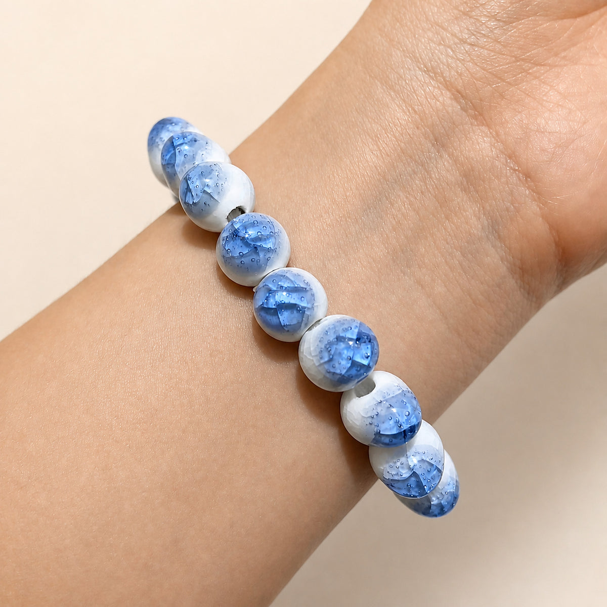 LUMI blue ice-crackle glaze ceramic bracelet 10mm worn on the wrist — handmade Jingdezhen porcelain, wrist shot 2
