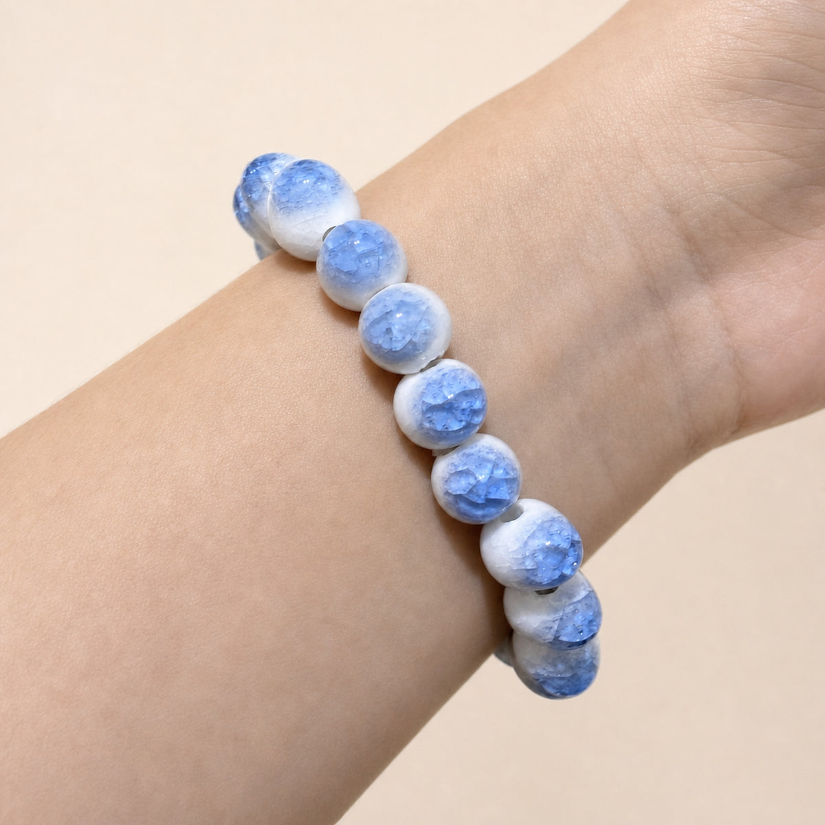 LUMI blue ice-crackle glaze ceramic bracelet 10mm worn on the wrist — handmade Jingdezhen porcelain, wrist shot 3