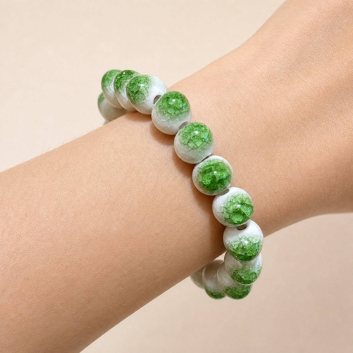 LUMI green ice-crackle glaze ceramic bracelet 10mm worn on the wrist — handmade Jingdezhen porcelain, wrist shot 1
