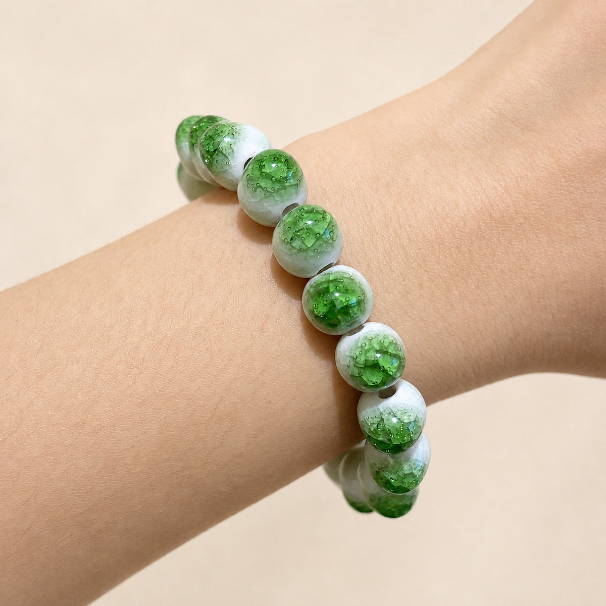 LUMI green ice-crackle glaze ceramic bracelet 10mm worn on the wrist — handmade Jingdezhen porcelain, wrist shot 2