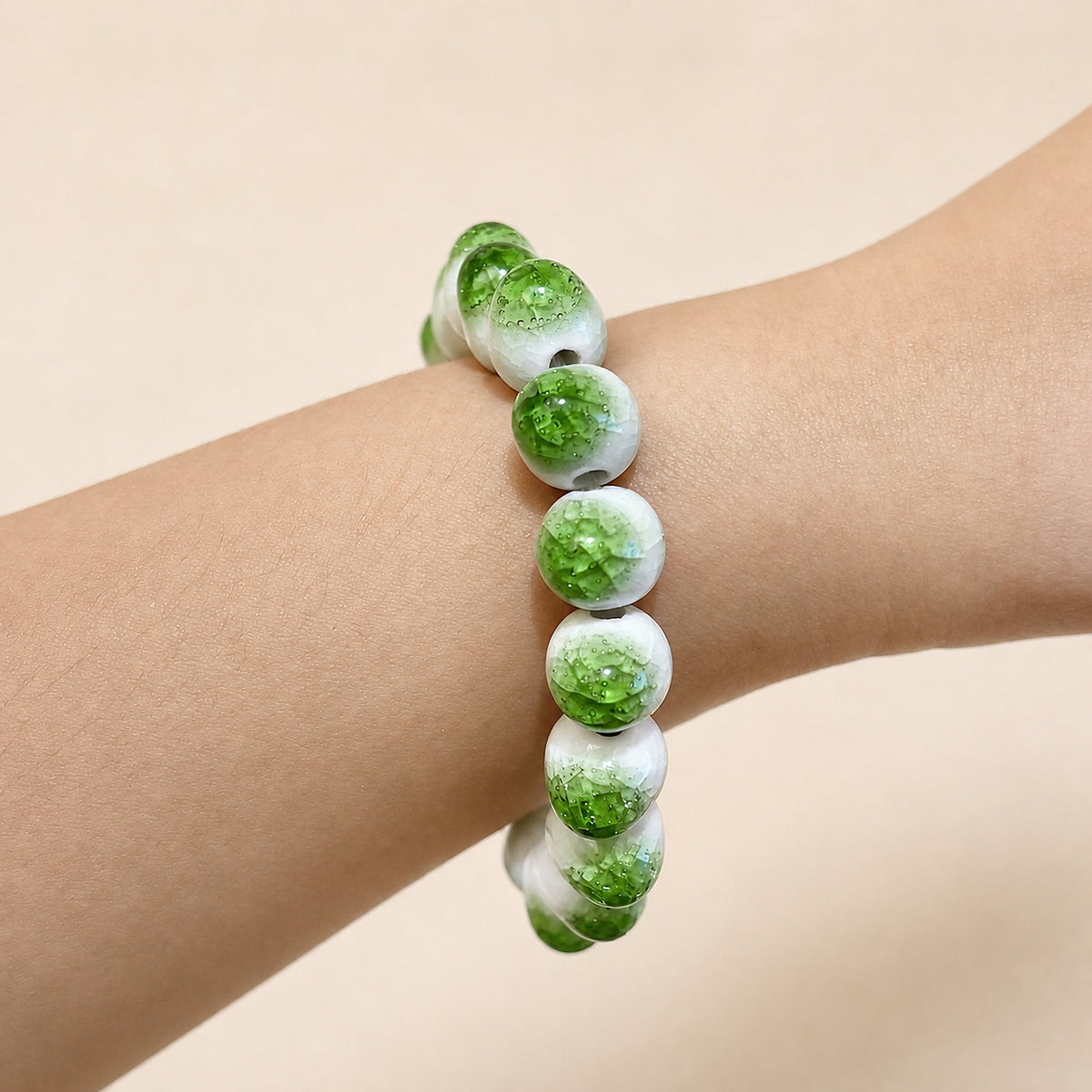 LUMI green ice-crackle glaze ceramic bracelet 10mm worn on the wrist — handmade Jingdezhen porcelain, wrist shot 3
