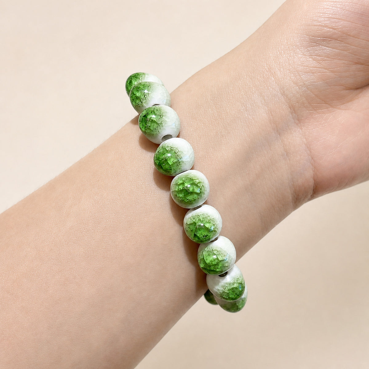 LUMI green ice-crackle glaze ceramic bracelet 10mm worn on the wrist — handmade Jingdezhen porcelain, wrist shot 4