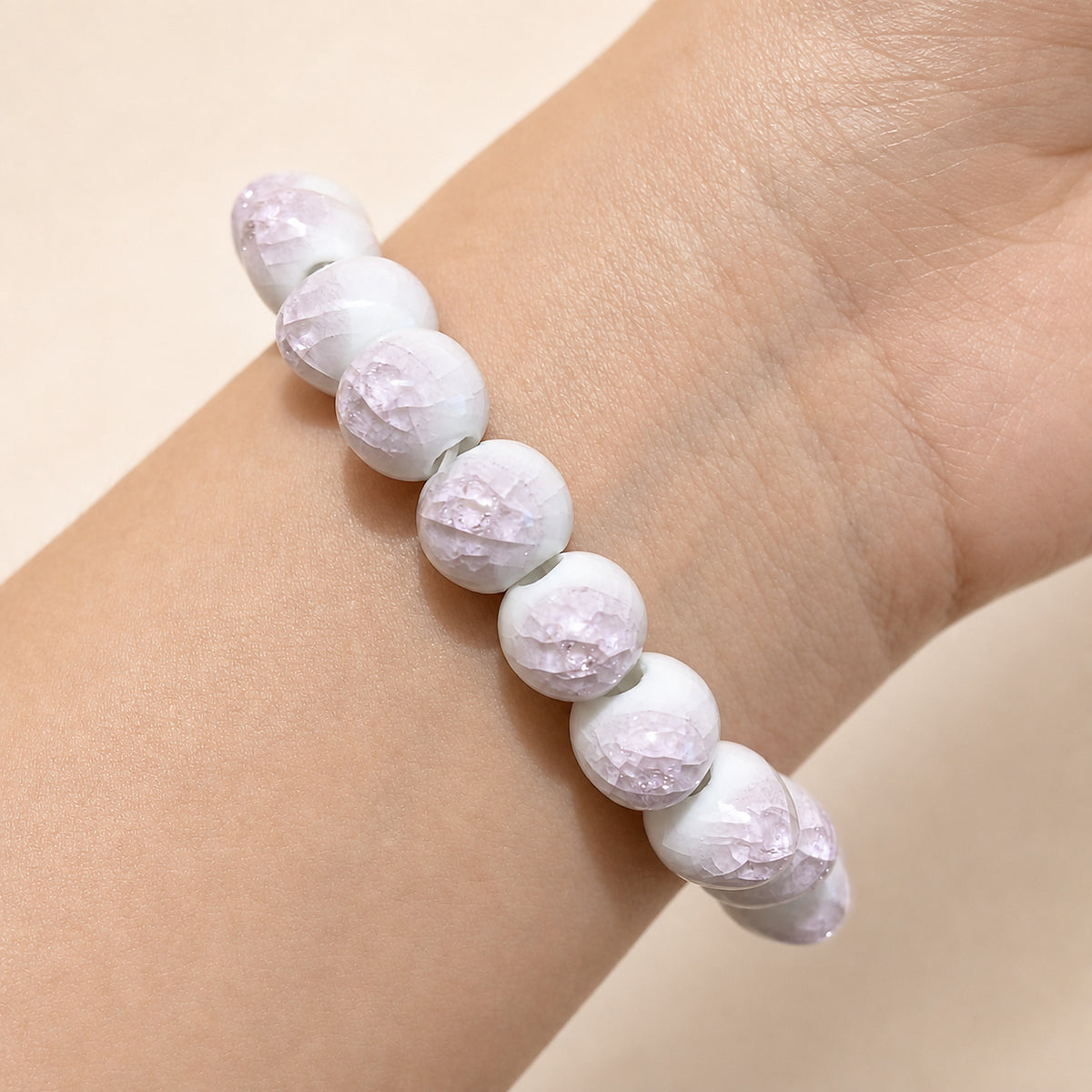 LUMI pink ice-crackle glaze ceramic bracelet 10mm worn on the wrist — handmade Jingdezhen porcelain, wrist shot 3