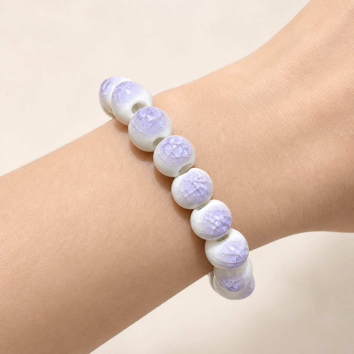LUMI purple ice-crackle glaze ceramic bracelet 10mm worn on the wrist — handmade Jingdezhen porcelain, wrist shot 1