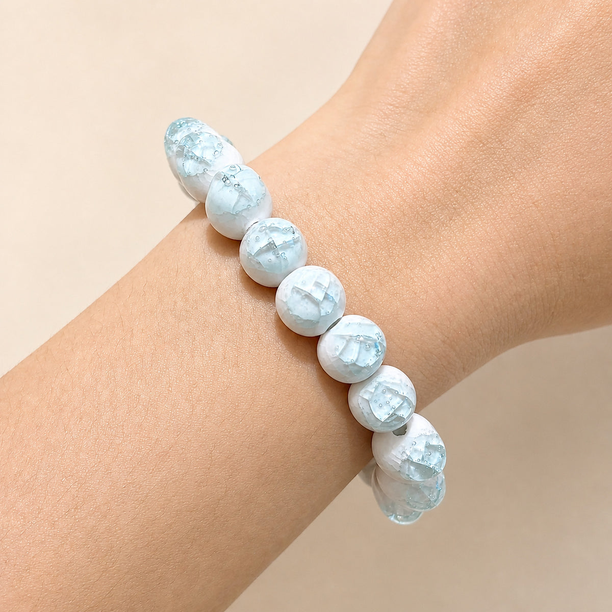 LUMI sky blue ice-crackle glaze ceramic bracelet 10mm worn on the wrist — handmade Jingdezhen porcelain, wrist shot 1