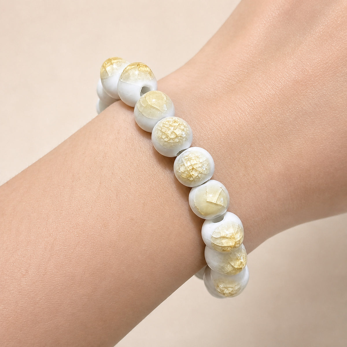 LUMI yellow ice-crackle glaze ceramic bracelet 10mm worn on the wrist — handmade Jingdezhen porcelain, wrist shot 1