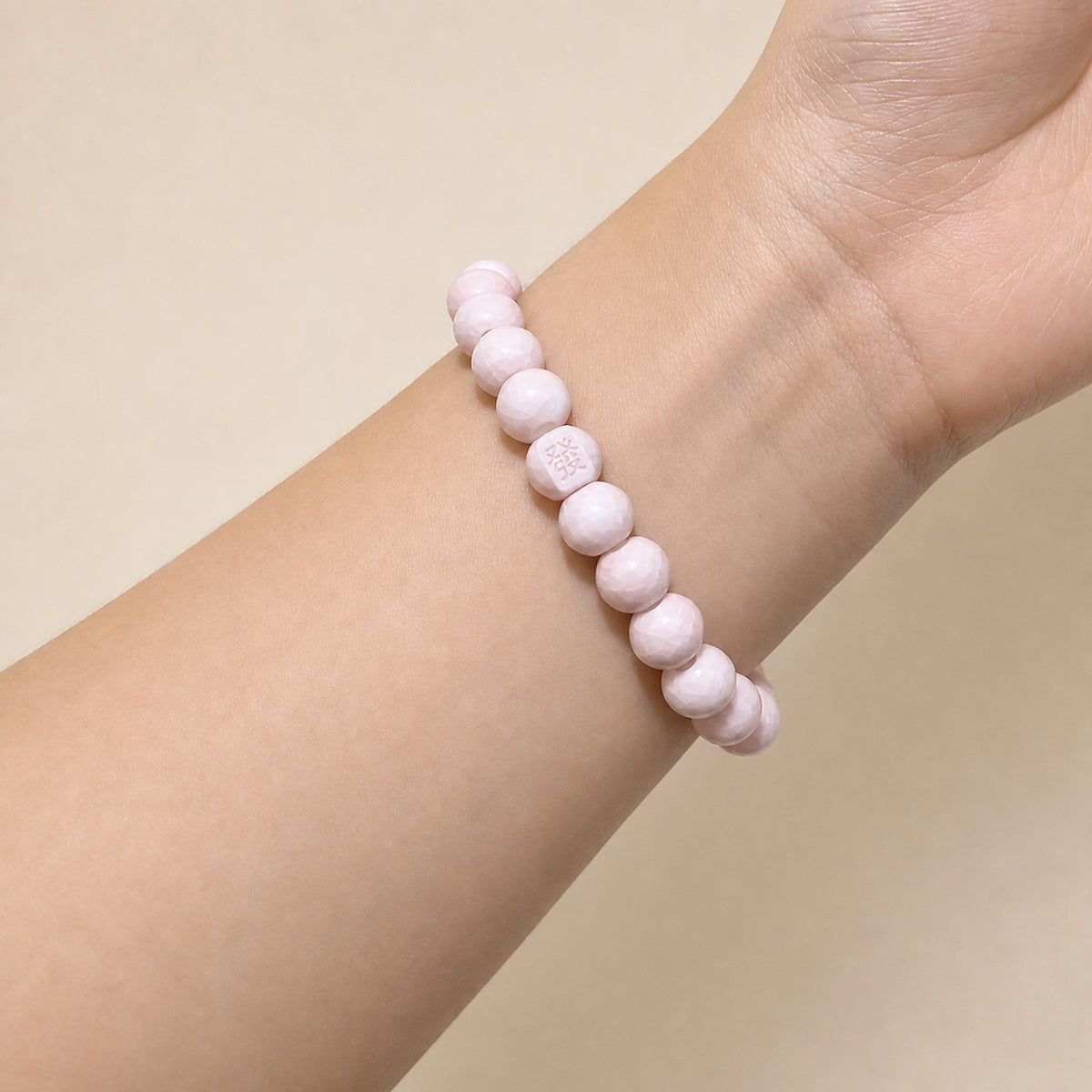 LUMI pink 發 fortune character ceramic bracelet 8mm worn on the wrist — handmade Jingdezhen porcelain, wrist shot 2