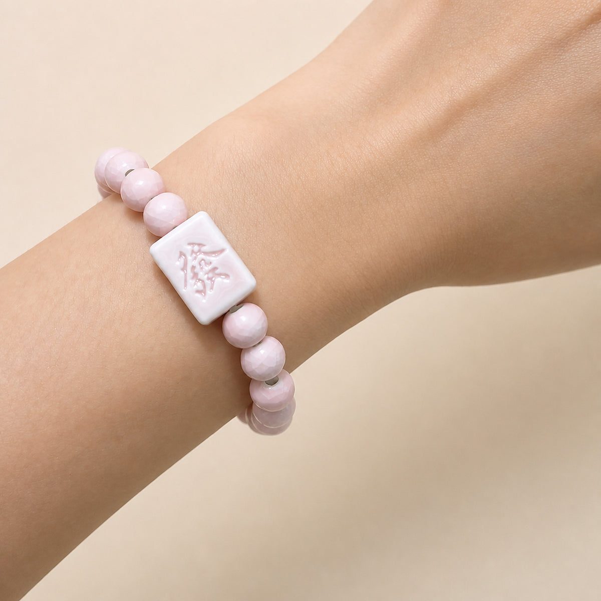 LUMI pink 發 fortune character ceramic bracelet 8mm worn on the wrist — handmade Jingdezhen porcelain, wrist shot 3