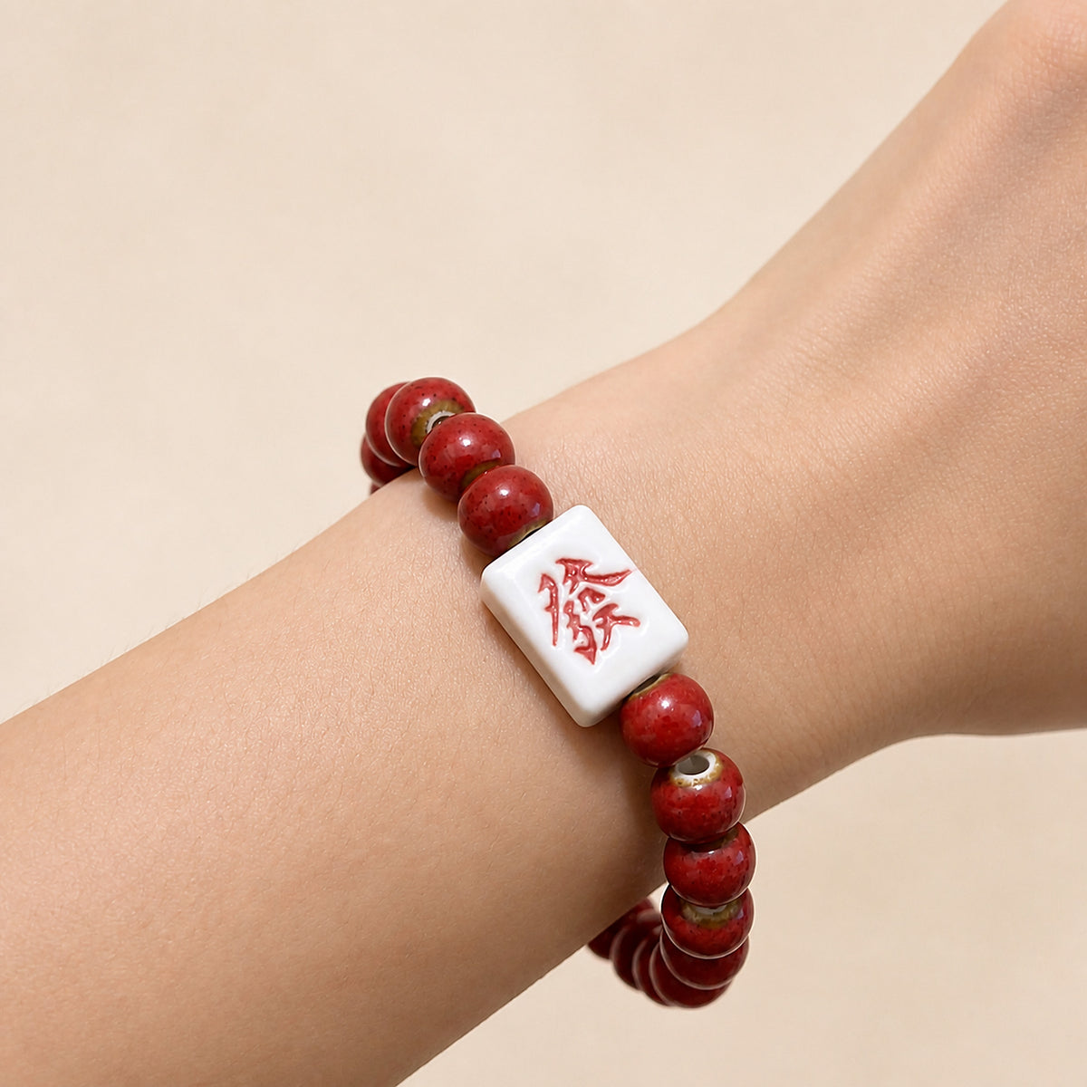 LUMI red 發 fortune character ceramic bracelet 8mm worn on the wrist — handmade Jingdezhen porcelain, wrist shot 1