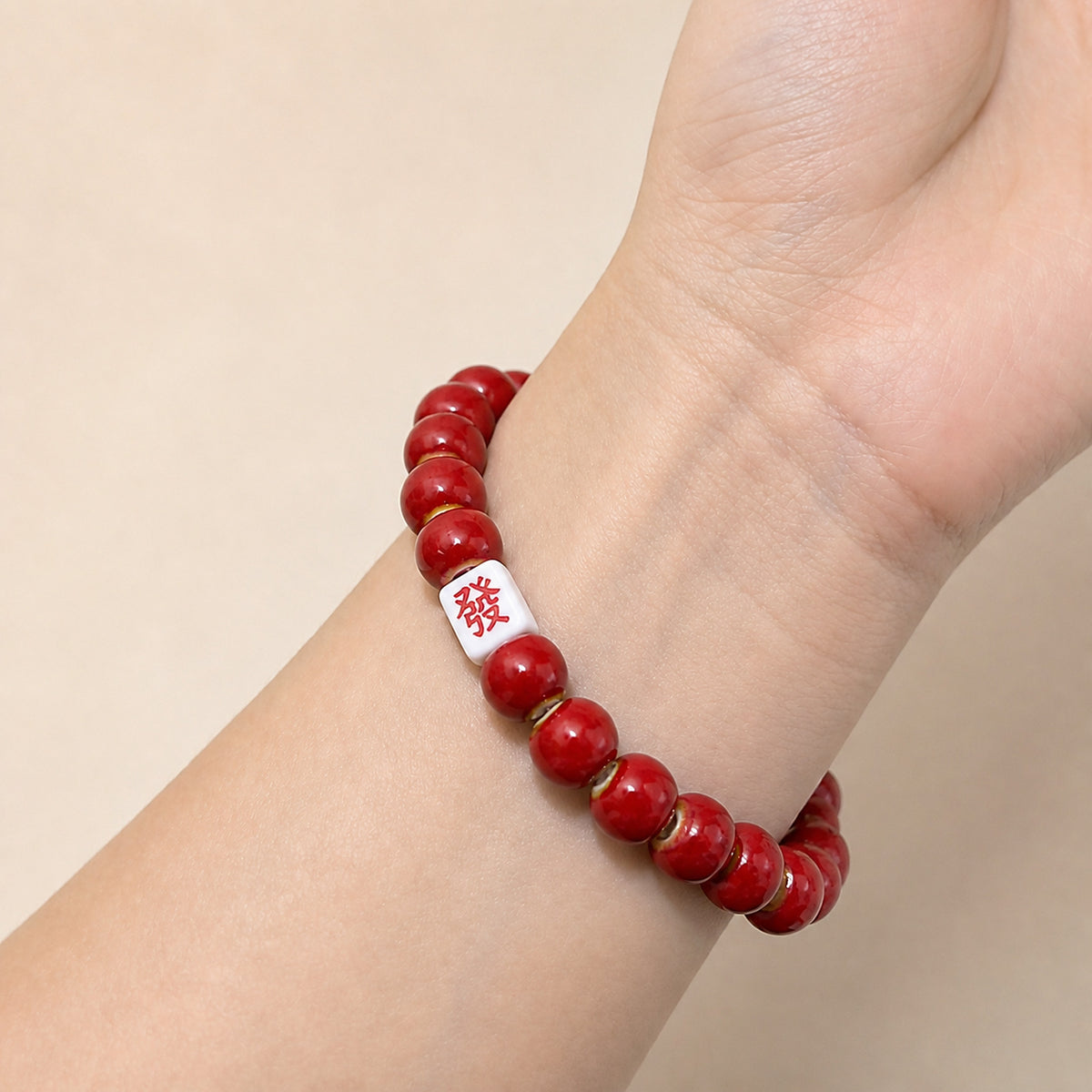 LUMI red 發 fortune character ceramic bracelet 8mm worn on the wrist — handmade Jingdezhen porcelain, wrist shot 3