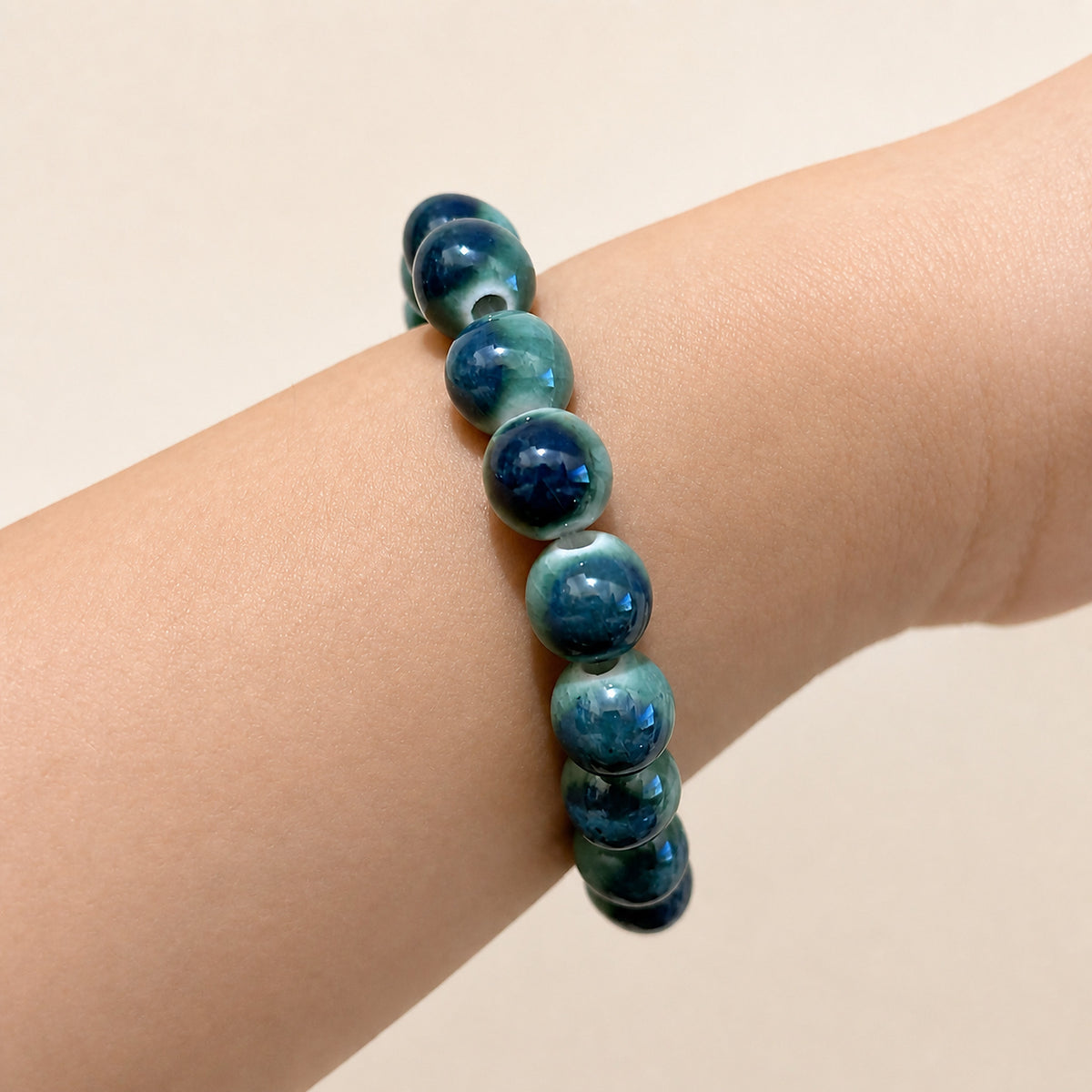 LUMI forest green ceramic bracelet 10mm worn on the wrist — handmade Jingdezhen porcelain, wrist shot 2