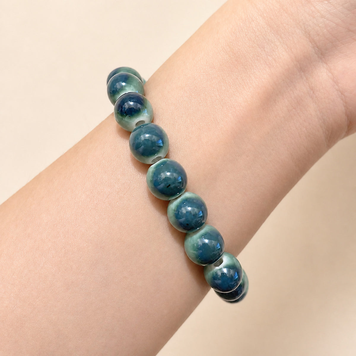 LUMI forest green ceramic bracelet 10mm worn on the wrist — handmade Jingdezhen porcelain, wrist shot 3