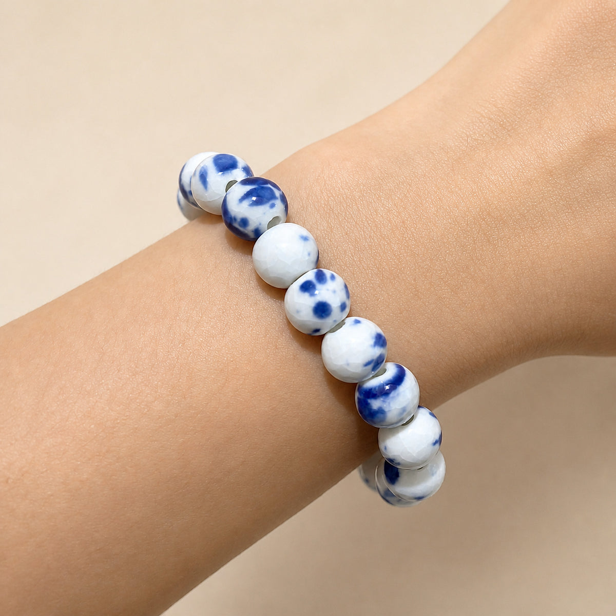 LUMI Qing Hua blue-and-white porcelain bracelet 10mm worn on the wrist — handmade Jingdezhen porcelain, wrist shot 1