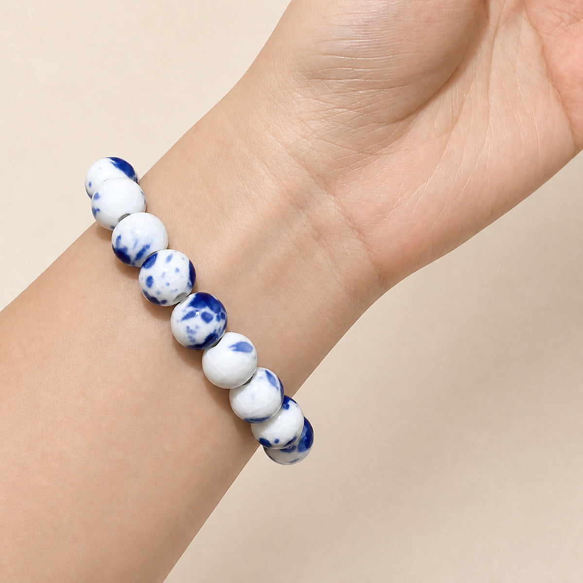 LUMI Qing Hua blue-and-white porcelain bracelet 10mm worn on the wrist — handmade Jingdezhen porcelain, wrist shot 2