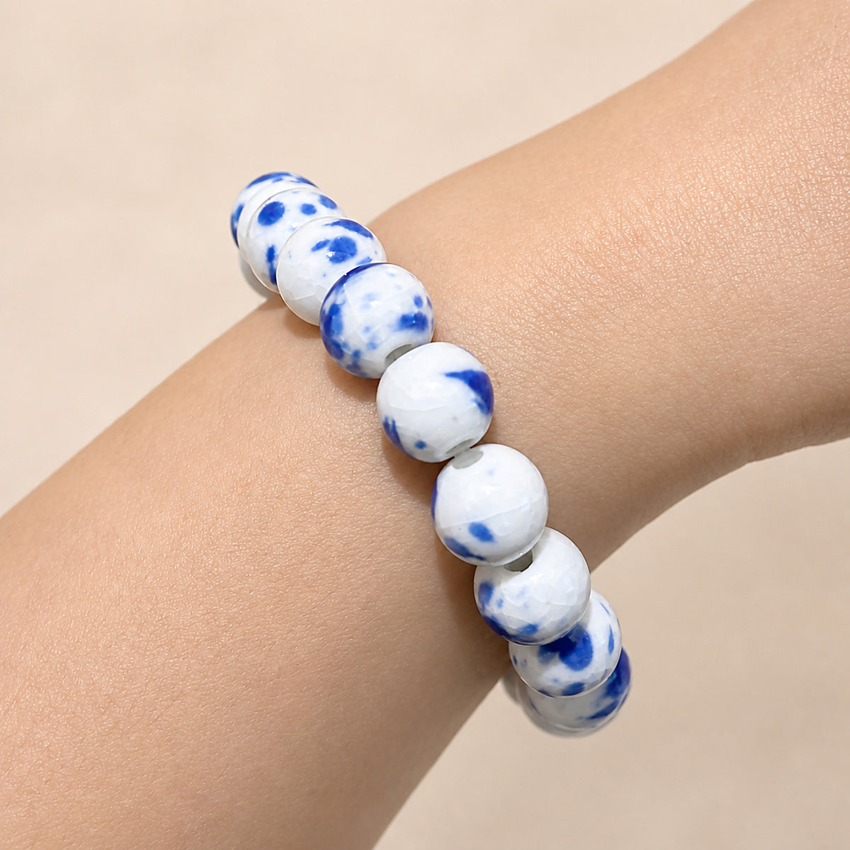 LUMI Qing Hua blue-and-white porcelain bracelet 10mm worn on the wrist — handmade Jingdezhen porcelain, wrist shot 4