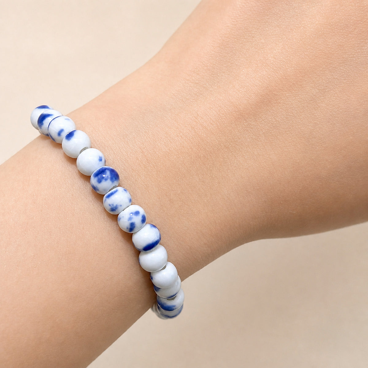 LUMI Qing Hua blue-and-white porcelain bracelet 6mm worn on the wrist — handmade Jingdezhen porcelain, wrist shot 1