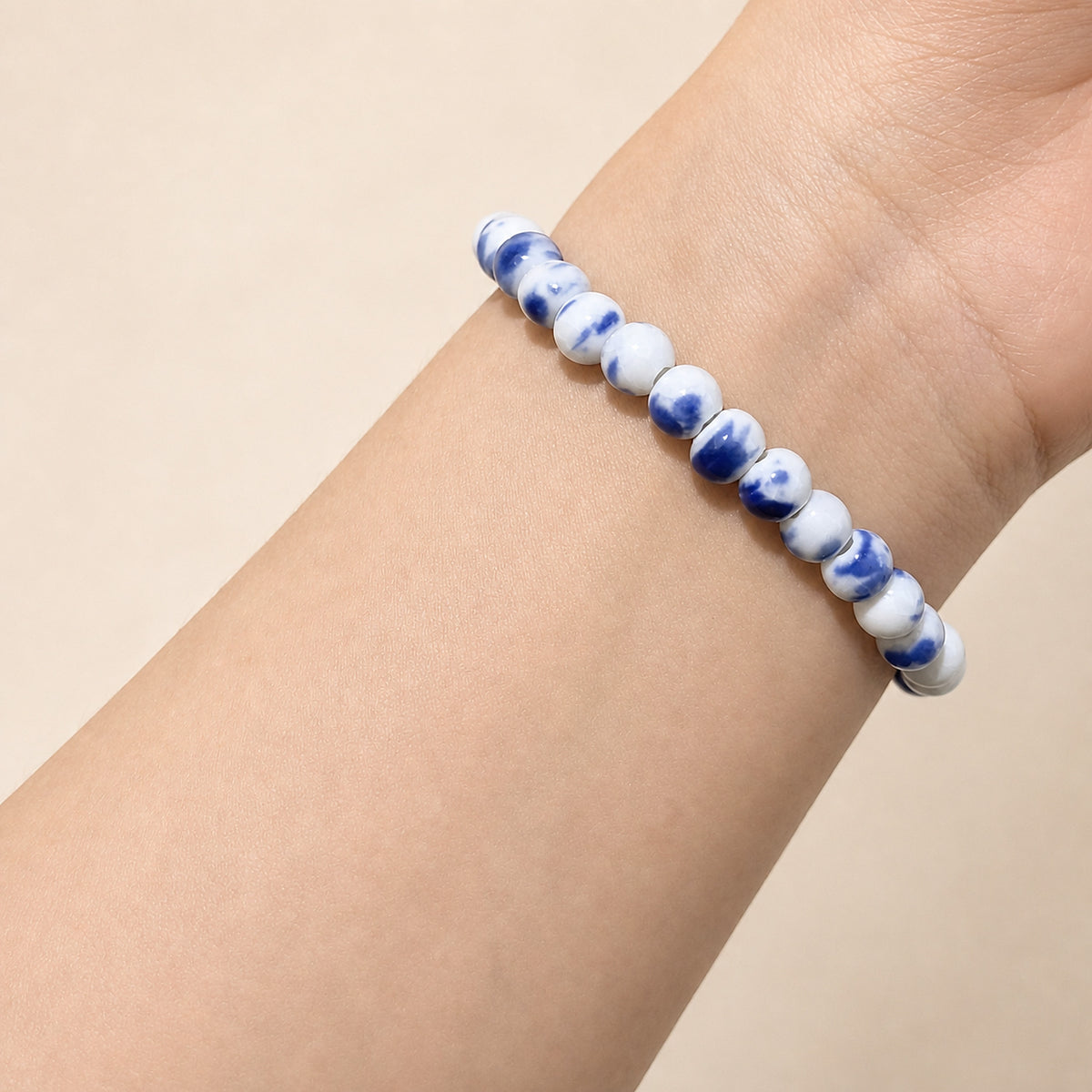 LUMI Qing Hua blue-and-white porcelain bracelet 6mm worn on the wrist — handmade Jingdezhen porcelain, wrist shot 2