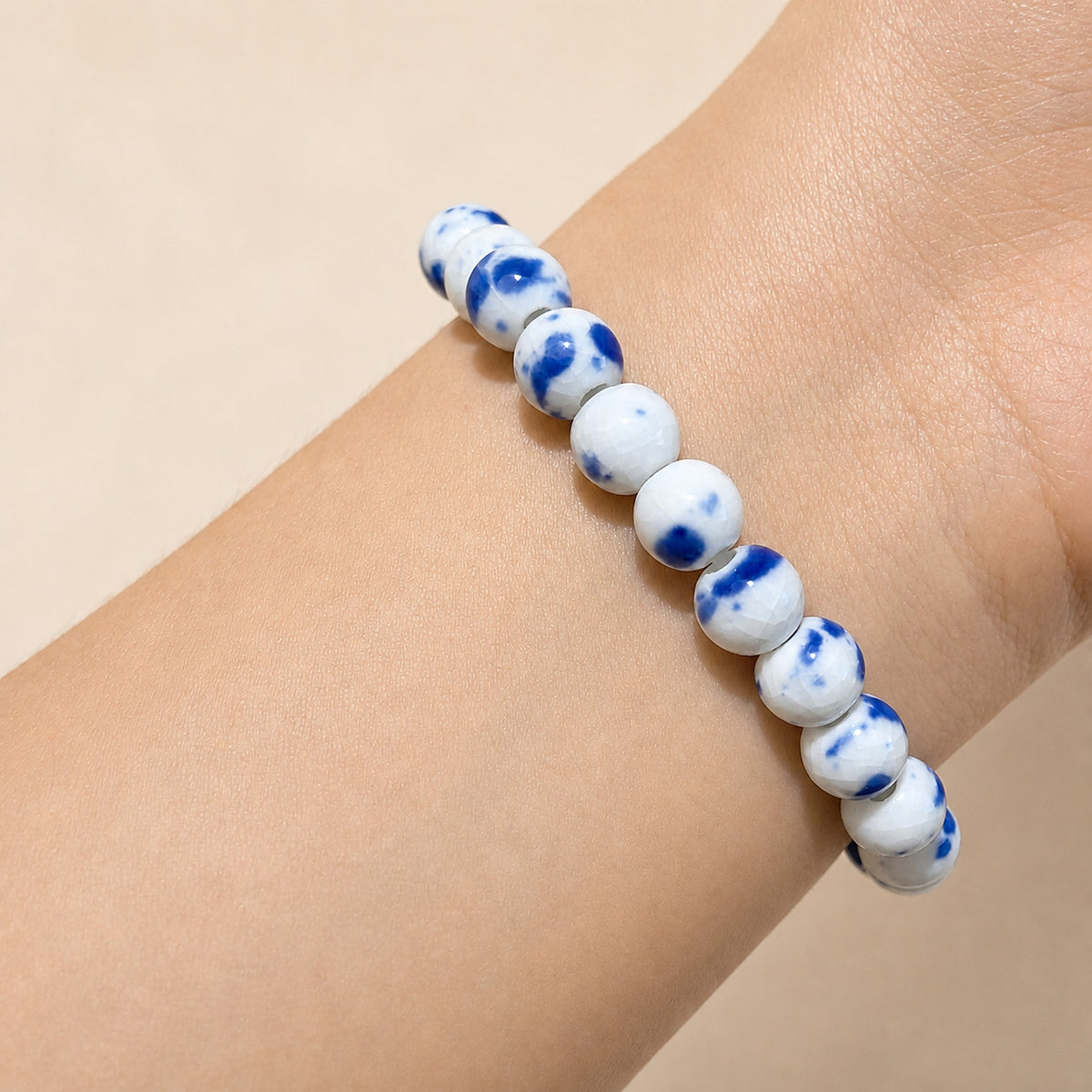 LUMI Qing Hua blue-and-white porcelain bracelet 8mm worn on the wrist — handmade Jingdezhen porcelain, wrist shot 2