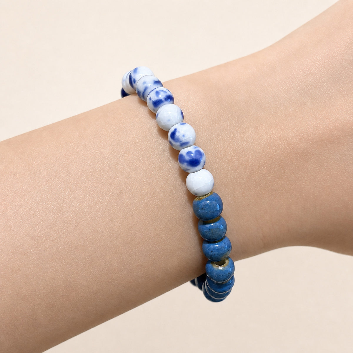 LUMI cobalt blue and Qing Hua mixed ceramic bracelet 6mm worn on the wrist — handmade Jingdezhen porcelain, wrist shot 2