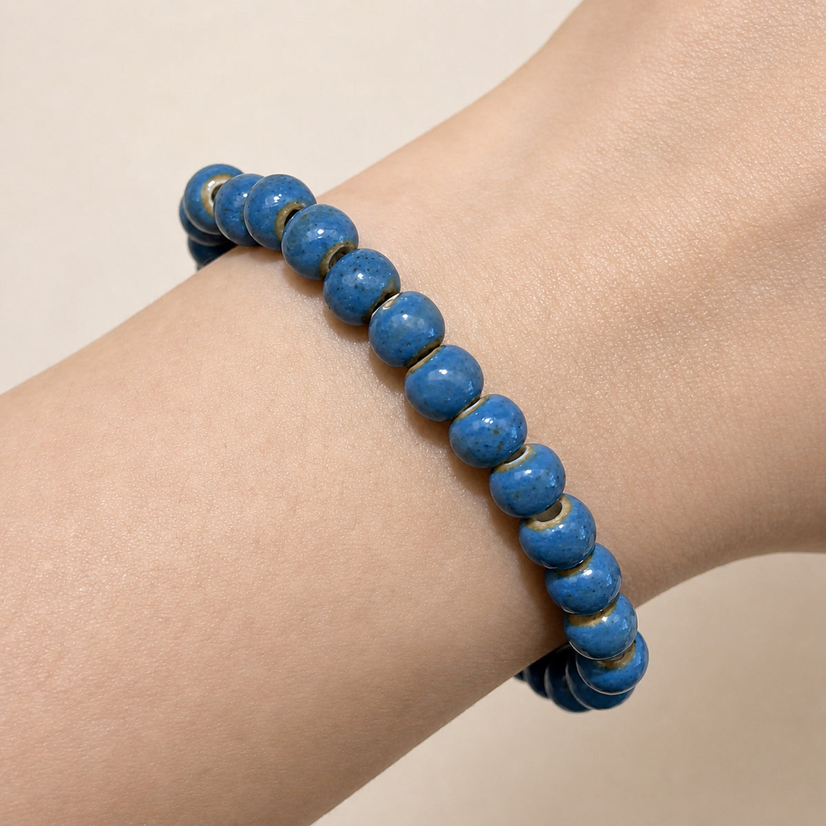LUMI cobalt blue ceramic bracelet 6mm worn on the wrist — handmade Jingdezhen porcelain, wrist shot 2