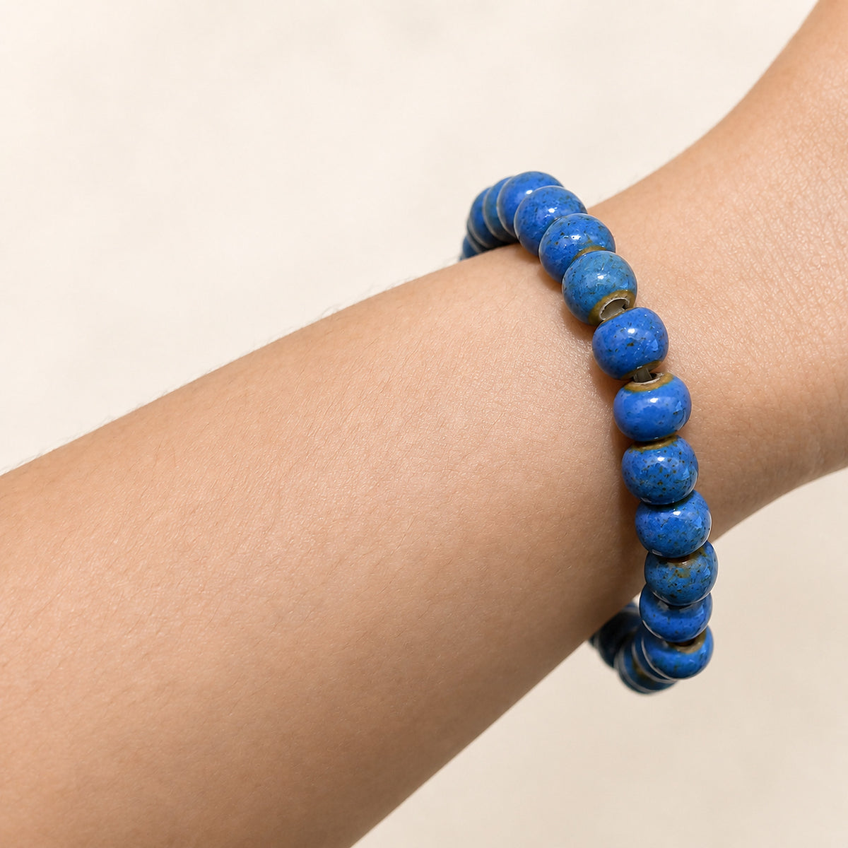 LUMI cobalt blue ceramic bracelet 6mm worn on the wrist — handmade Jingdezhen porcelain, wrist shot 3