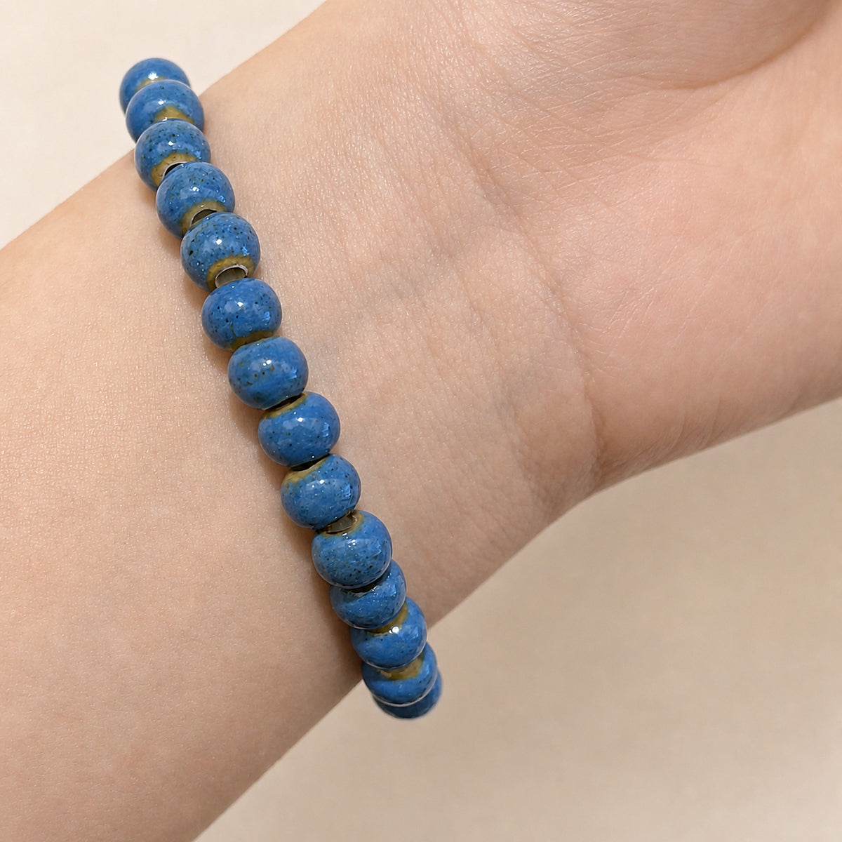 LUMI cobalt blue ceramic bracelet 6mm worn on the wrist — handmade Jingdezhen porcelain, wrist shot 4